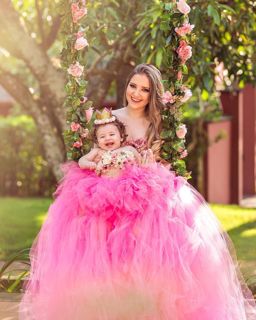 Família Mãe e Bebê no Balanço com Flores